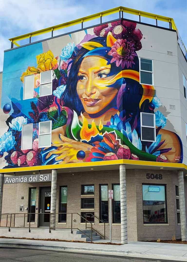 Nochtli – Prickly Pear, a 40-by-58-foot mural by Bimmer Torres at Avenida del Sol in Denver, featuring a woman surrounded by colorful flowers and prickly pear cactus imagery.